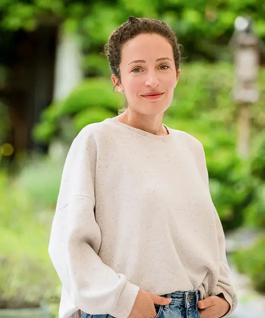 white woman with white shirt hands in trousers pockets