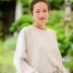 white woman with white shirt hands in trousers pockets
